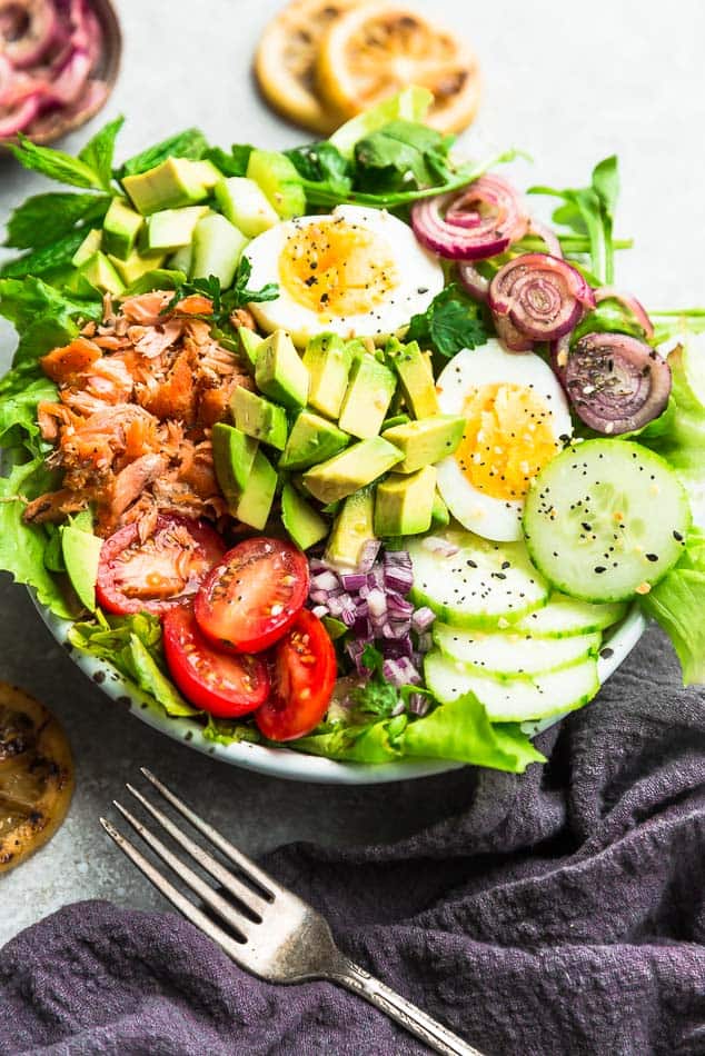 The side view of a salmon salad in a bowl on top of a kitchen counter