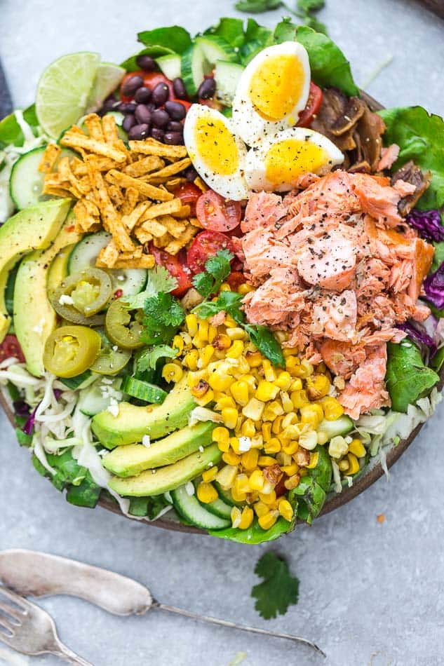 Overhead view of Salmon Taco Salad with corn, avocado, eggs, and tortilla strips