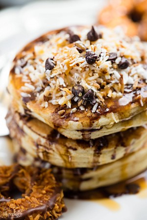 These Samoa Pancakes are the perfect way to enjoy the popular Girl Scout Cookie all year round. Best of all, these soft and fluffy pancakes are so easy to make with layers of toasted coconut, melted chocolate and gooey caramel.