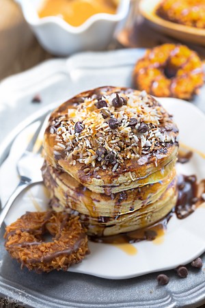 These Samoa Pancakes are the perfect way to enjoy the popular Girl Scout Cookie all year round. Best of all, these soft and fluffy pancakes are so easy to make with layers of toasted coconut, melted chocolate and gooey caramel.