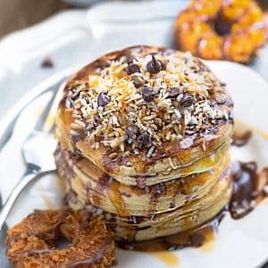 These Samoa Pancakes are the perfect way to enjoy the popular Girl Scout Cookie all year round. Best of all, these soft and fluffy pancakes are so easy to make with layers of toasted coconut, melted chocolate and gooey caramel.