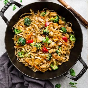 Asian Sesame Chicken Noodles - a one pot 30 minute meal perfect to curb those takeout cravings. Made with chicken, veggies, gluten free rice noodles and a delicious savory Asian-inspired sauce.