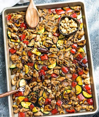 Top view of Sheet Pan Kung Pao Chicken on a pan with a wooden spoon