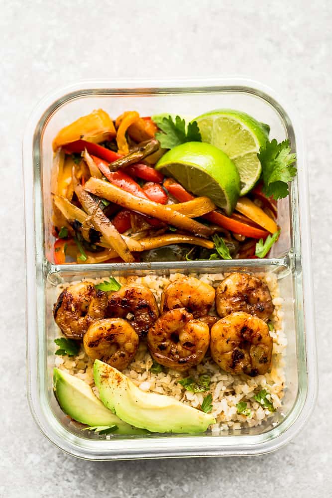 Shrimp Fajitas in a meal prep lunch container with cauliflower rice and avocado