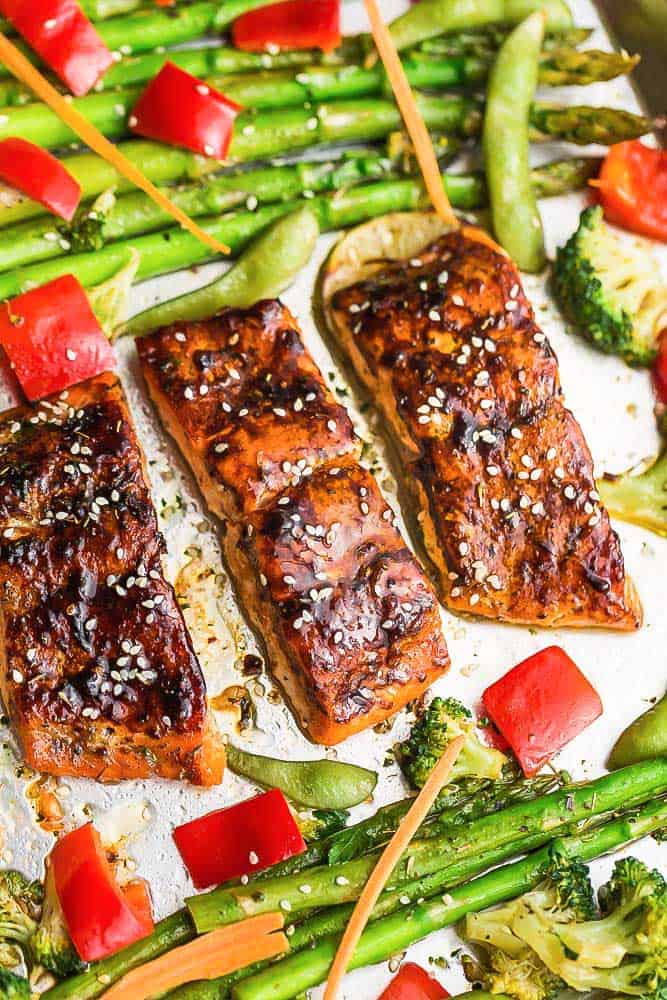 Asian Teriyaki Baked Salmon surrounded by roasted asparagus, broccoli, and red bell peppers