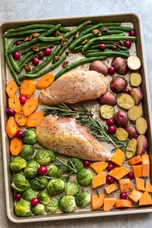 Sheet Pan Turkey Dinner For Two - an easy and healthy one pan Thanksgiving meal for two (or four). Best of all, everything cooks up in under an hour. Includes a juicy turkey, potatoes, green beans, carrots, sweet potatoes and cranberries. 