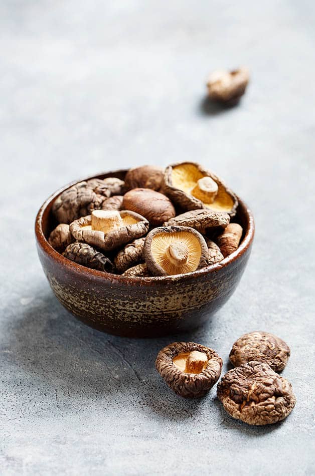 bowl of edible mushrooms on grey surface