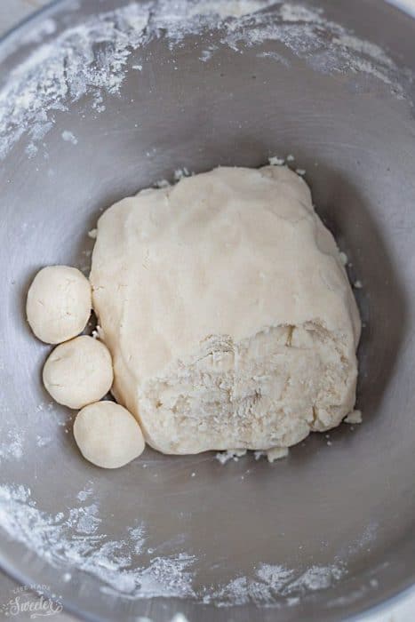 Shortbread dough with a few small dough balls in a mixing bowl