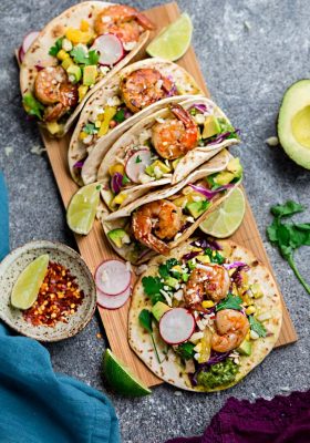 Healthy Shrimp Tacos - made with a delicious spicy seasoning and come together in 30 minutes – perfect for your next Taco Tuesday! Best of all, instructions to make this on the grill or stove and packed with avocado, lettuce, red cabbage, pineapple and avocado cream.