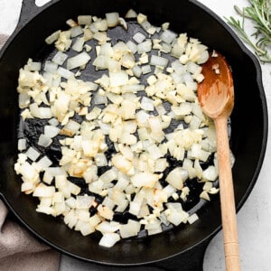 Diced onions being sauteed in a skillet