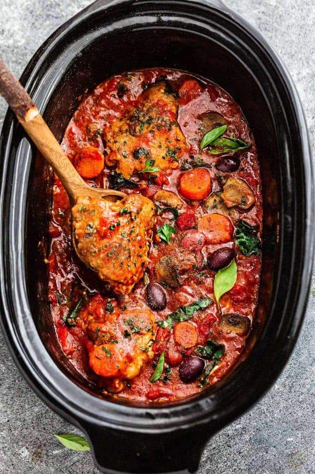 Crock Pot Chicken Cacciatore being stirred with a wooden spoon