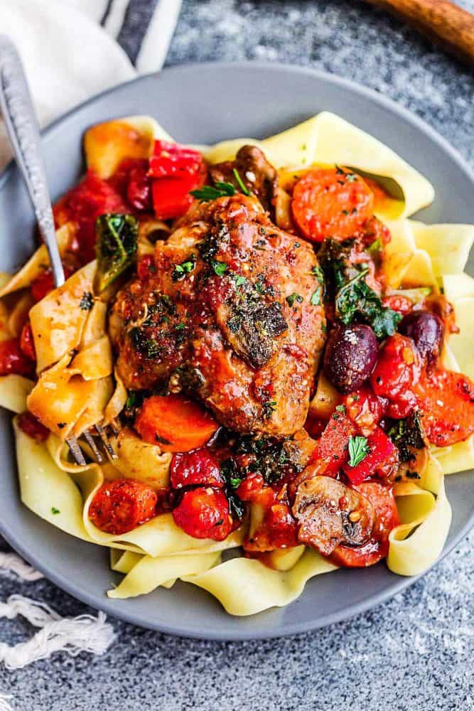 Dinner plate of slow cooker chicken cacciatore served over thick egg noodles