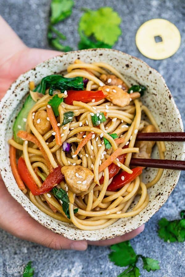 Top view of a serving of Slow Cooker Chicken Lo Mein in a bowl with chopsticks