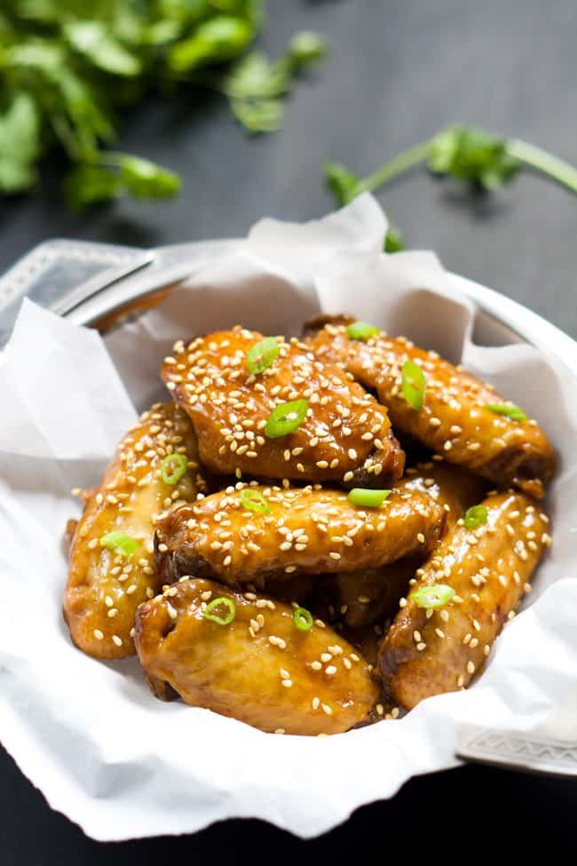 Slow Cooker Honey Garlic Chicken Wings with scallions and sesame seeds on top
