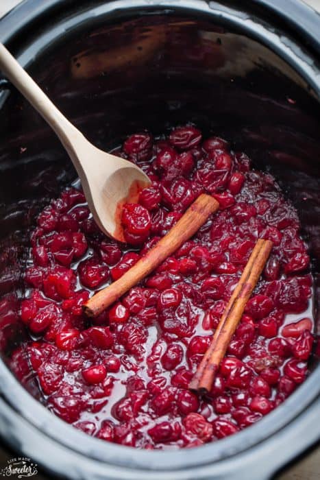 Overhead view of Slow Cooker Homemade Cranberry Sauce in a slow cooker with cinnamon sticks