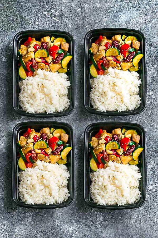 Top view of four meal prep containers of Kung Pao Chicken with rice