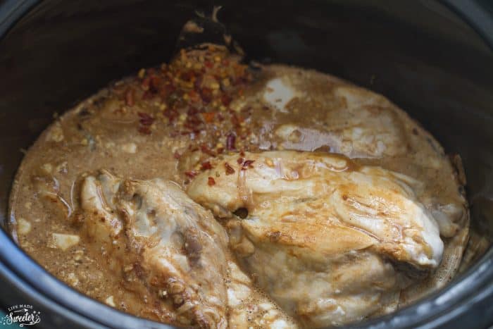 Top view of chicken in slow cooker pot. 