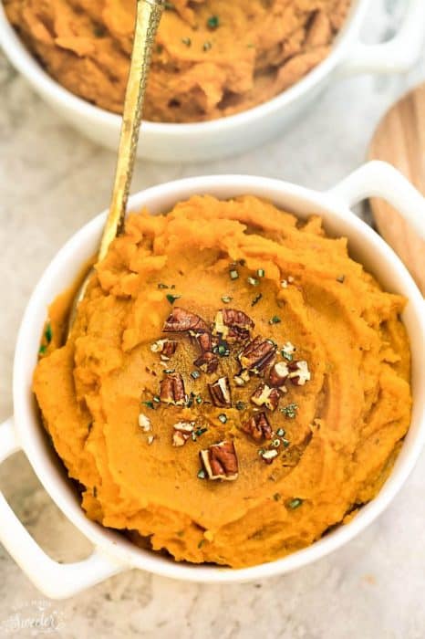 Top view of sweet potato mash in a white bowl with a gold spoon