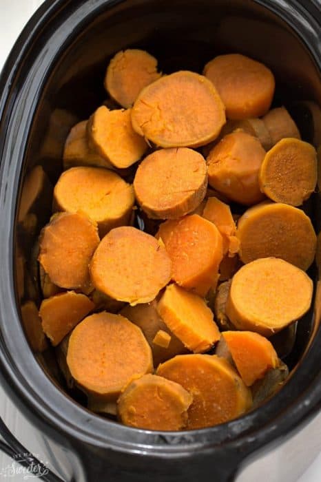 Top view of cooked sweet potato rounds in a slow cooker