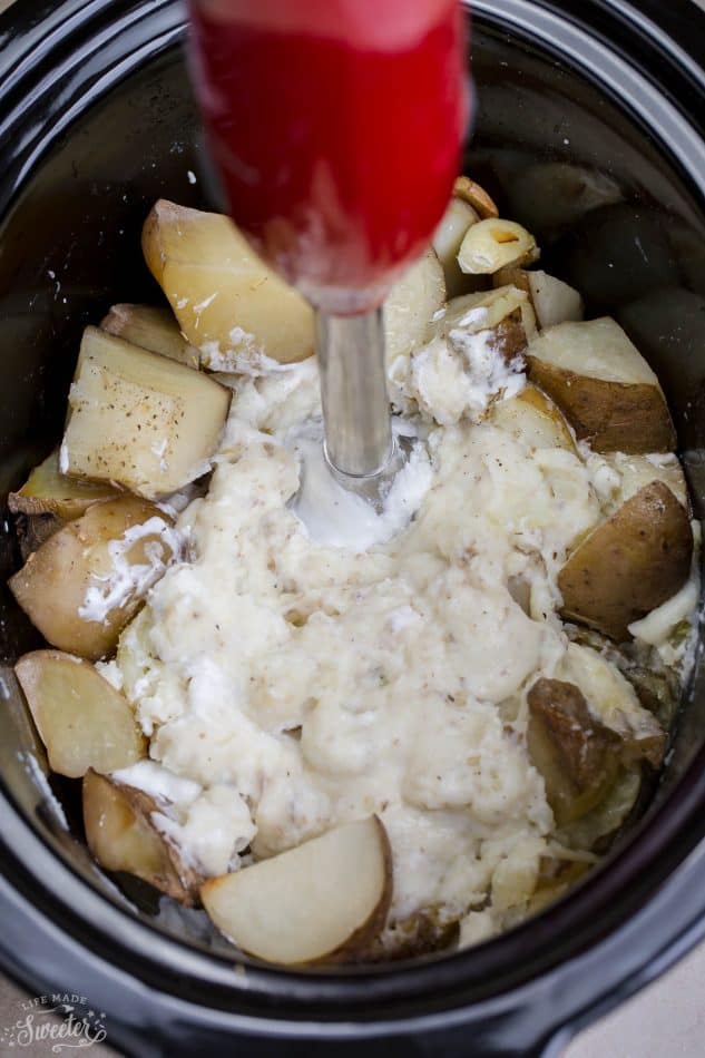Top view of immersion blender with Russet potatoes in a 6 quart slow cooker