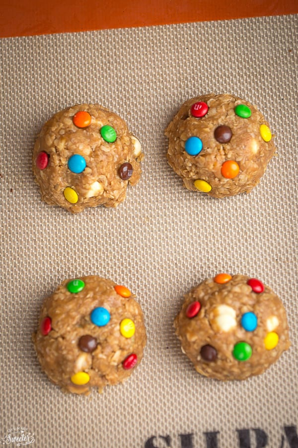 Overhead view of Soft and Chewy Oatmeal Monster M&M Cookie dough balls on a baking mat