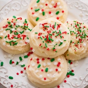Frosted eggnog cookies with red and green sprinkles on a plate