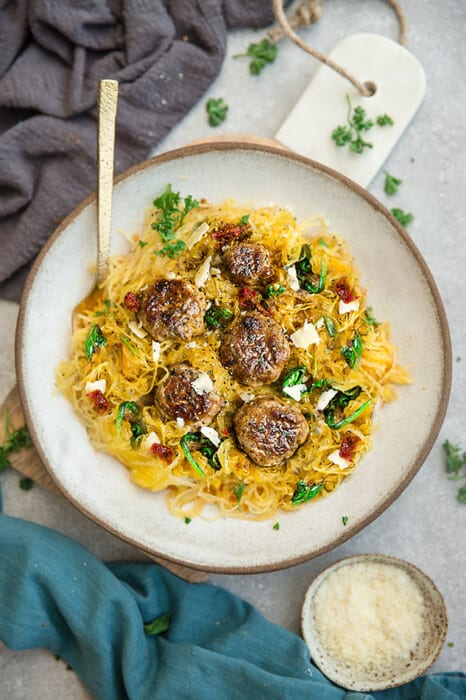 Top view of air fried spaghetti squash with meatballs on a white plate with a fork