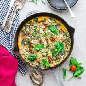 Top view of Spinach Frittata with Sun-Dried Tomatoes in a Grey Cast Iron Skillet Pan