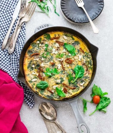 Top view of Spinach Frittata with Sun-Dried Tomatoes in a Grey Cast Iron Skillet Pan