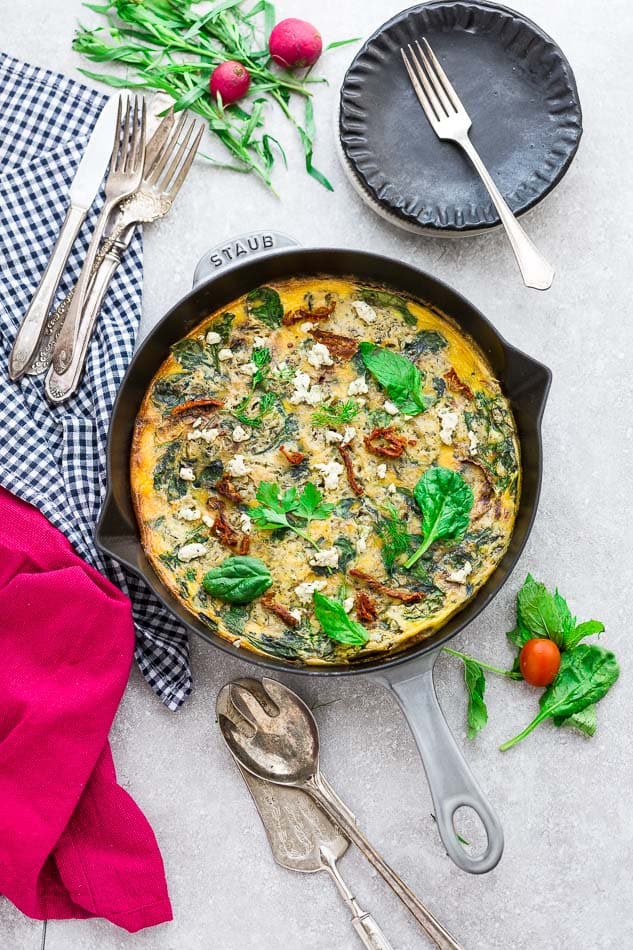 Top view of Spinach Frittata with Sun-Dried Tomatoes in a Grey Cast Iron Skillet Pan