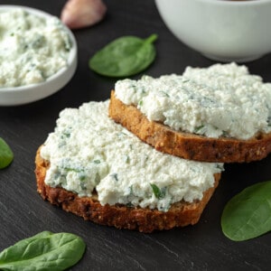 Two slices of grilled cheese with feta on a grey slate board