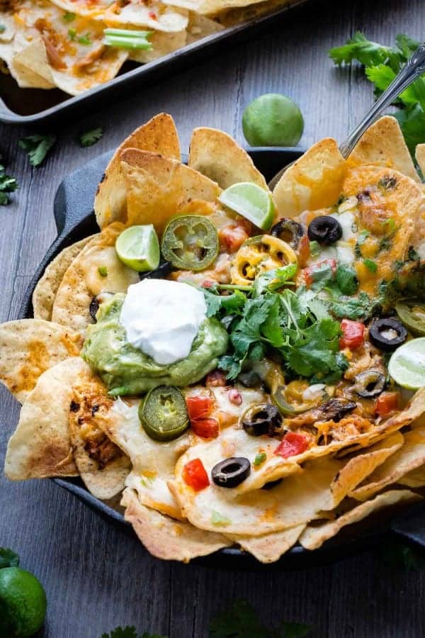 Close-up view of Sriracha Honey Chicken Nachos in a cast-iron skillet