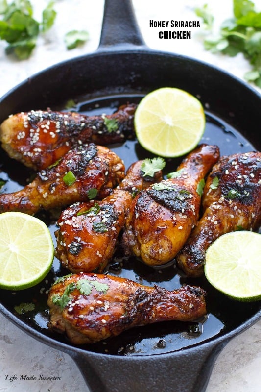 Sticky Honey Sriracha Chicken in a skillet with lime halves