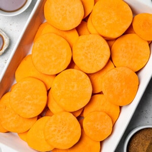 Overhead view of sliced sweet potatoes in a baking dish
