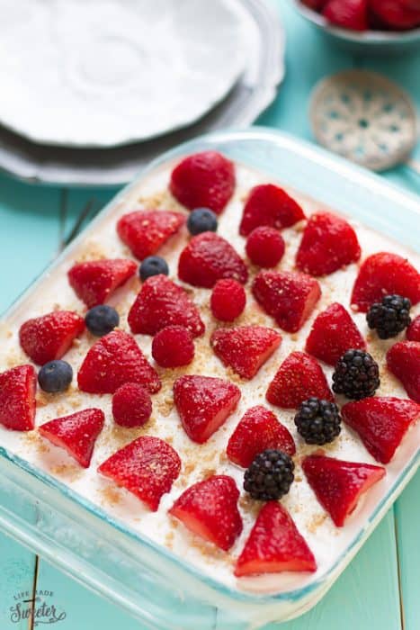 Top view of a square pan of Strawberry Cheesecake Icebox Cake topped with fresh berries
