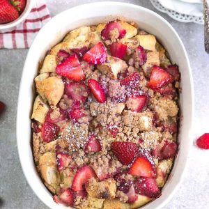 An overhead shot of a baked Strawberry French Toast Casserole in a white oval casserole dish