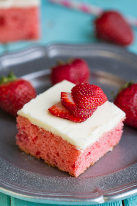 A piece of Strawberry Frosted Sheet Cake on a metal plate