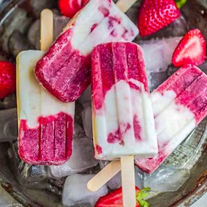 Top view of strawberry popsicles with fresh strawberries.