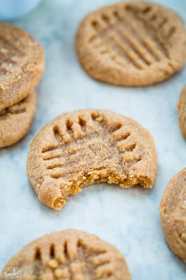 A close-up shot of a keto peanut butter cookie with a bite taken out to reveal the chewy interior