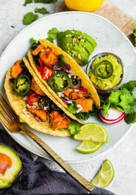 Two sweet potato tacos in grain-free taco shells on a white plate