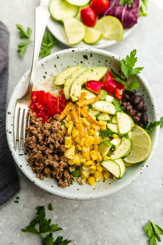 Taco Bowl in a white bowl with corn, tomatoes, beans and avocado