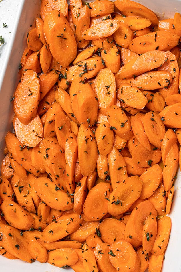 Close-up of air fried seasoned carrots in a white rectangle baking dish