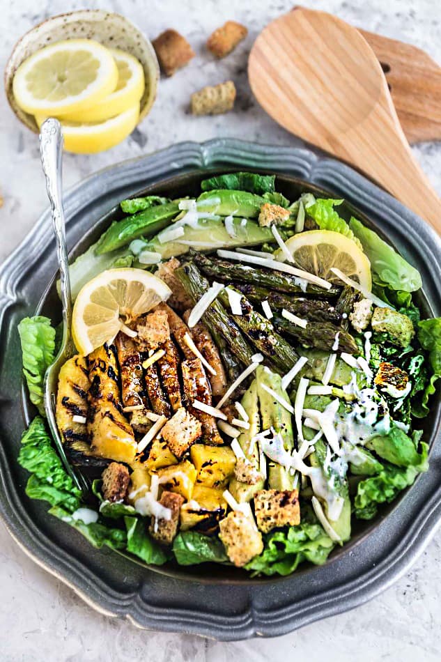 Top view of Teriyaki Chicken Caesar Salad on a black plate