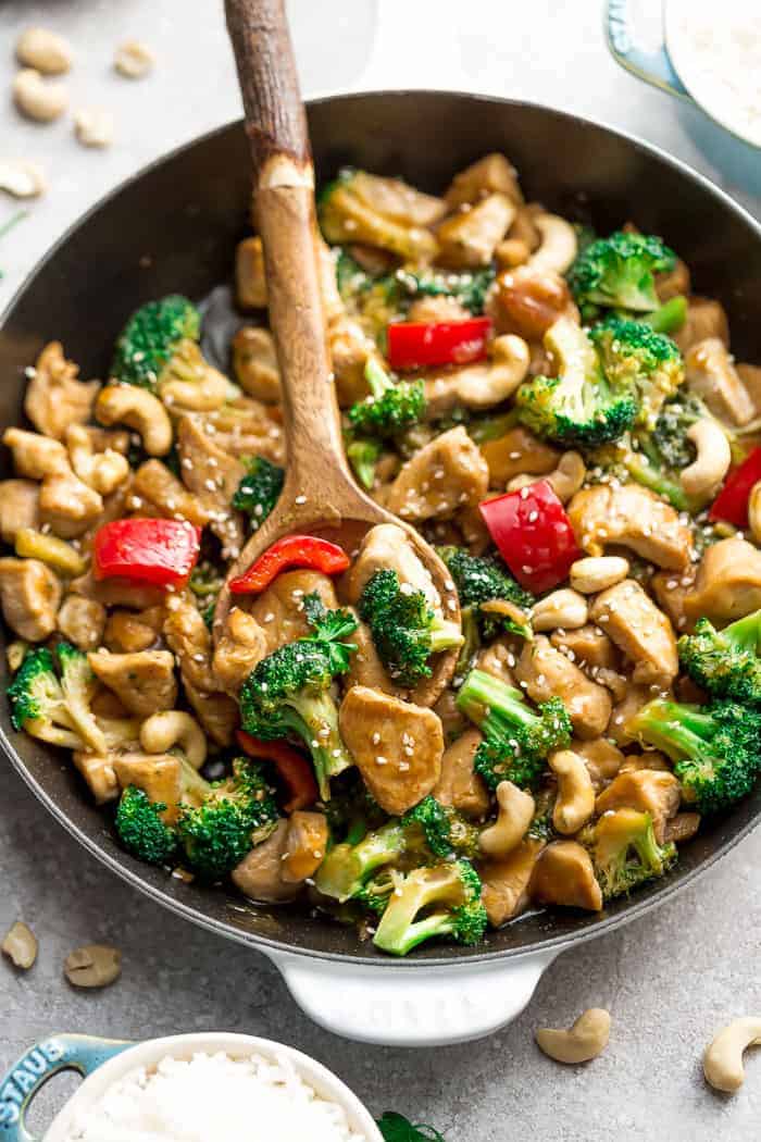 A close-up shot of a cast-iron skillet full of teriyaki chicken and vegetables