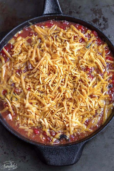 Skillet Tex Mex Casserole topped with shredded cheese in a skillet