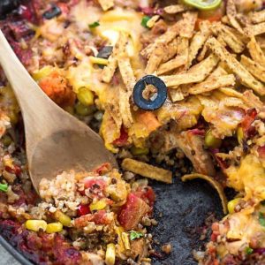 Skillet Tex Mex Casserole in a skillet with a couple scoops removed