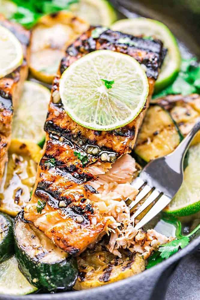 A Grilled Salmon Fillet in a Cast Iron Skillet with a Thin Slice of Lime on Top