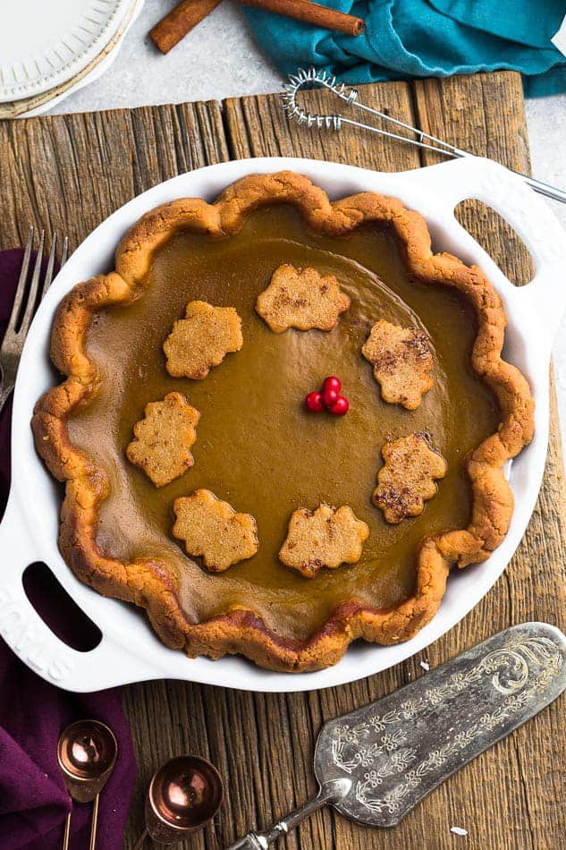 Top view of the best keto pumpkin pie in a white pie plate on a wooden background