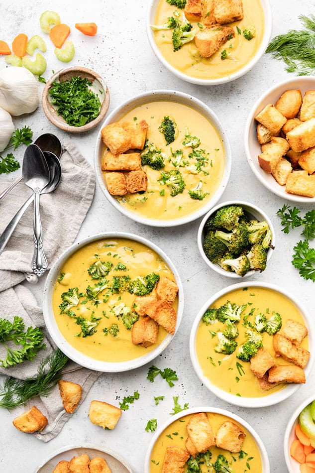 Three Vegan Broccoli Soups in white bowls with toasted sour dough slice