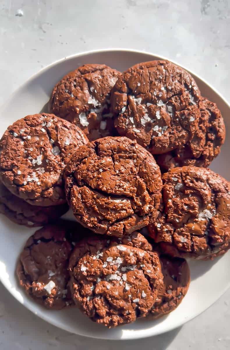 Top view of stacked Chocolate Brownie Cookies spread out on a white plate..